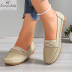 Vue de face et de trois quarts de mocassins beige clair à enfiler avec ornement métallique et surpiqûres apparentes