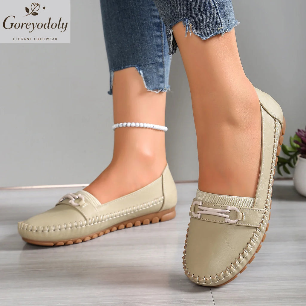 Vue de profil et de face de mocassins beige clair à enfiler avec ornement métallique mors et semelle nervurée camel
